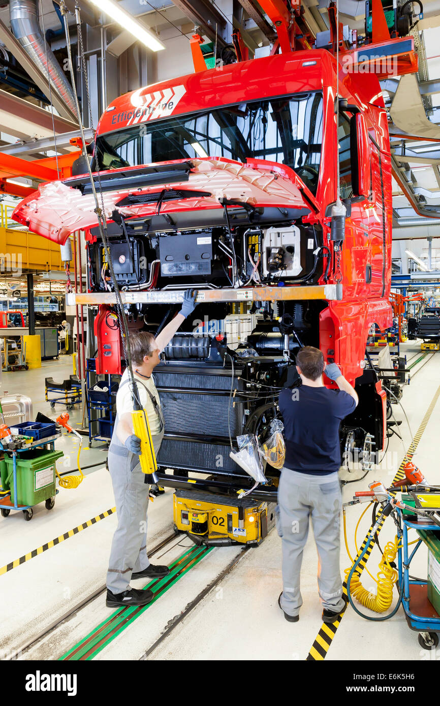 Employees assembling the chassis, engine and gearbox to the cab, at MAN Truck and Bus AG, Munich, Upper Bavaria, Bavaria Stock Photo