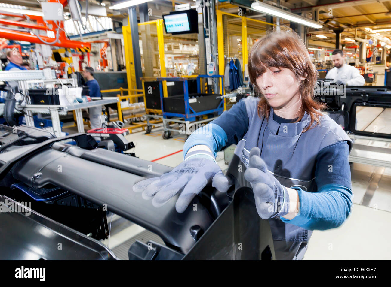 Female employee during the assembly of a leadframe, at MAN Truck and Bus AG, Munich, Upper Bavaria, Bavaria, Germany Stock Photo