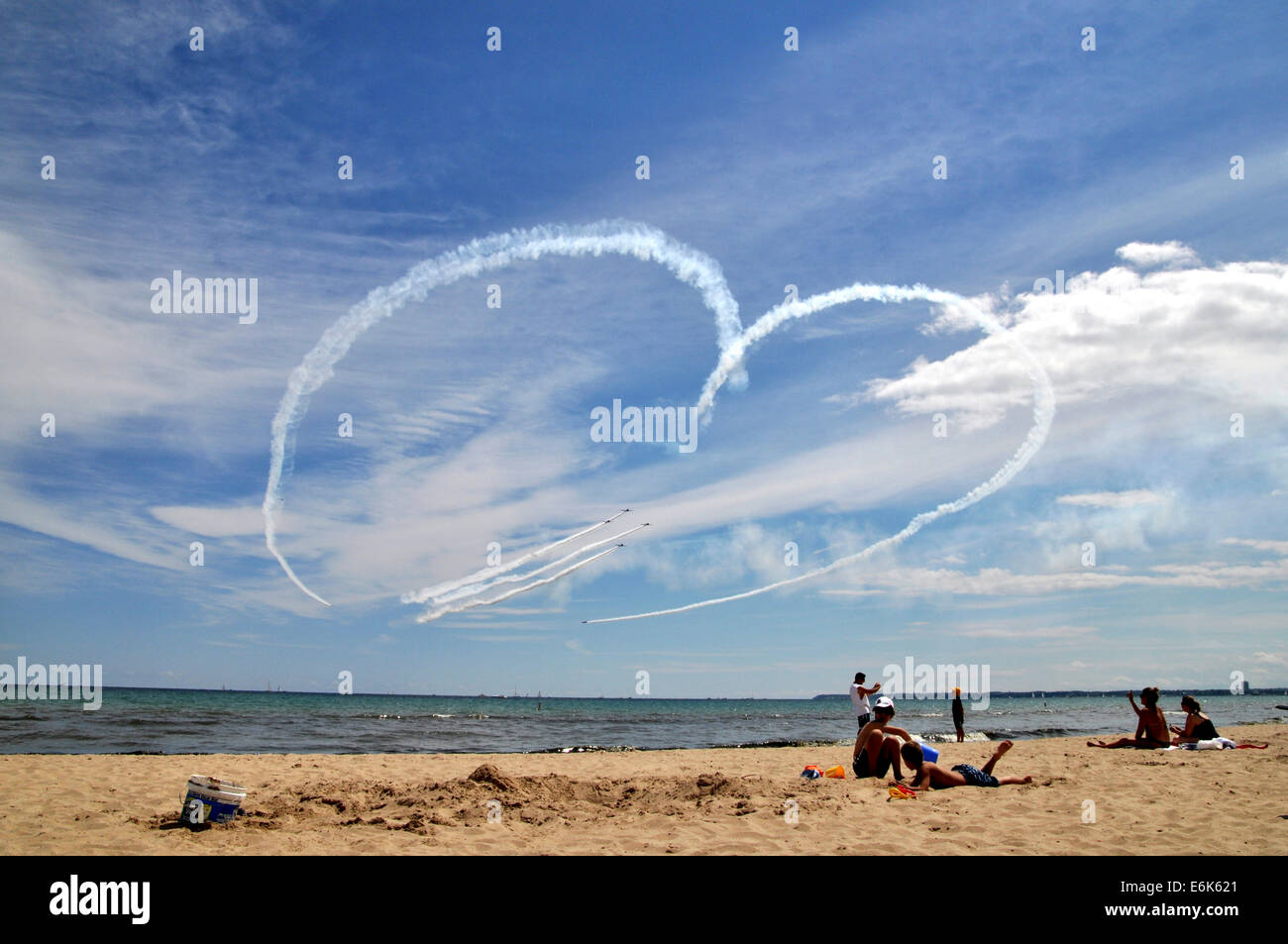 Airplanes draw heart in the sky and fighter jets fly through it, Milwaukee Air Show, Bradford Beach, Milwaukee, Wisconsin, USA Stock Photo