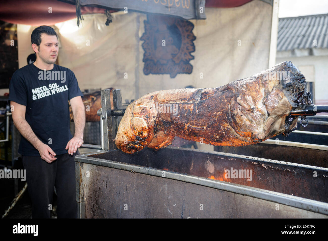 Man roasting whole pig on a spit Stock Photo