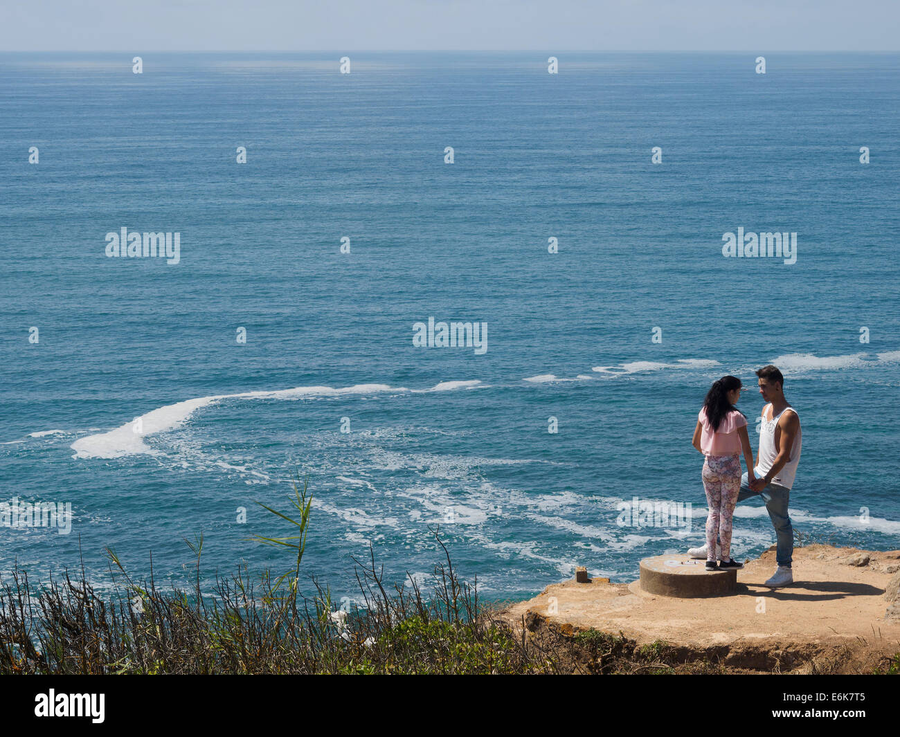 Young couple on a cliff by the sea Stock Photo