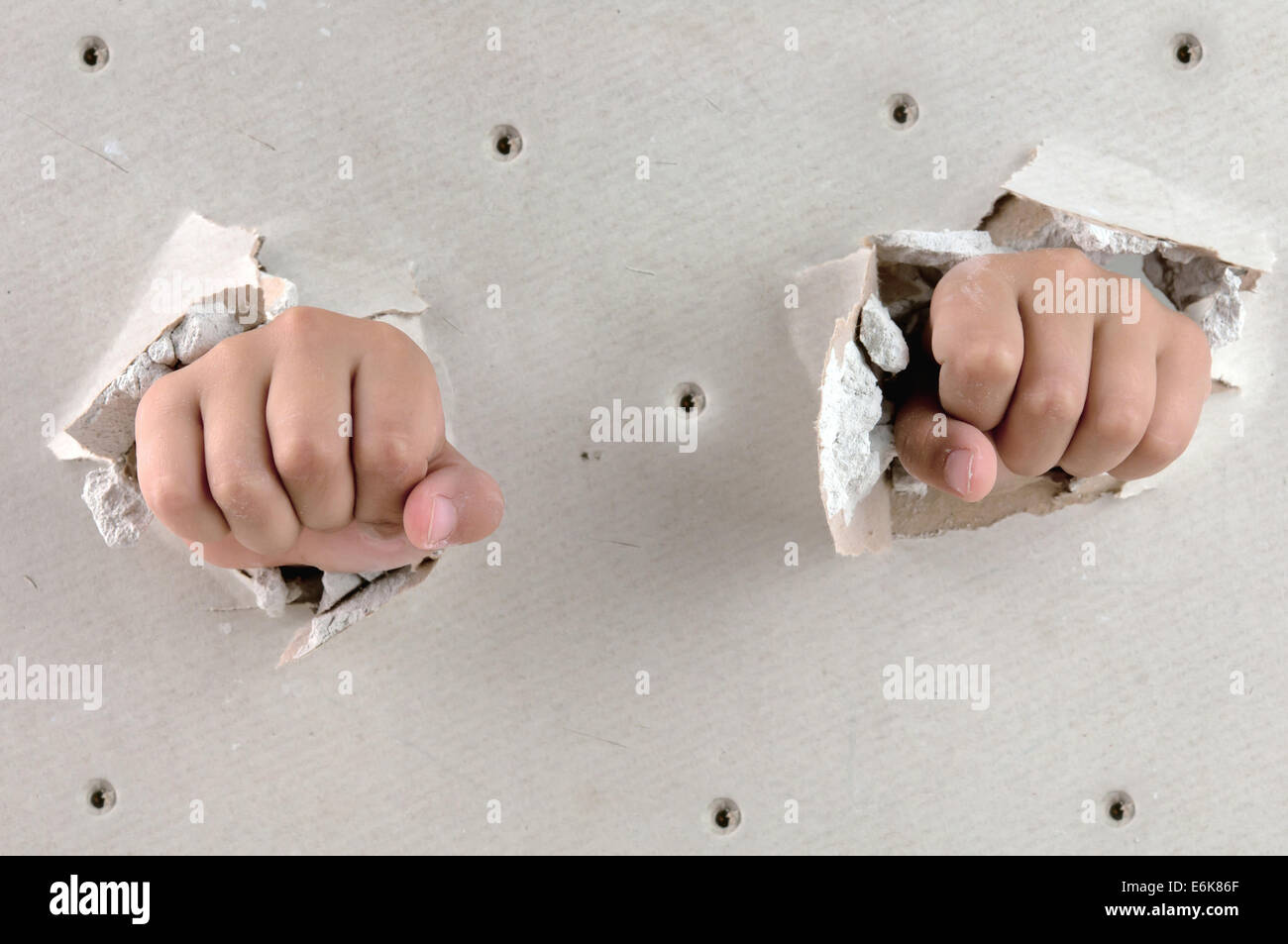 a wall is broken through by a two fist Stock Photo