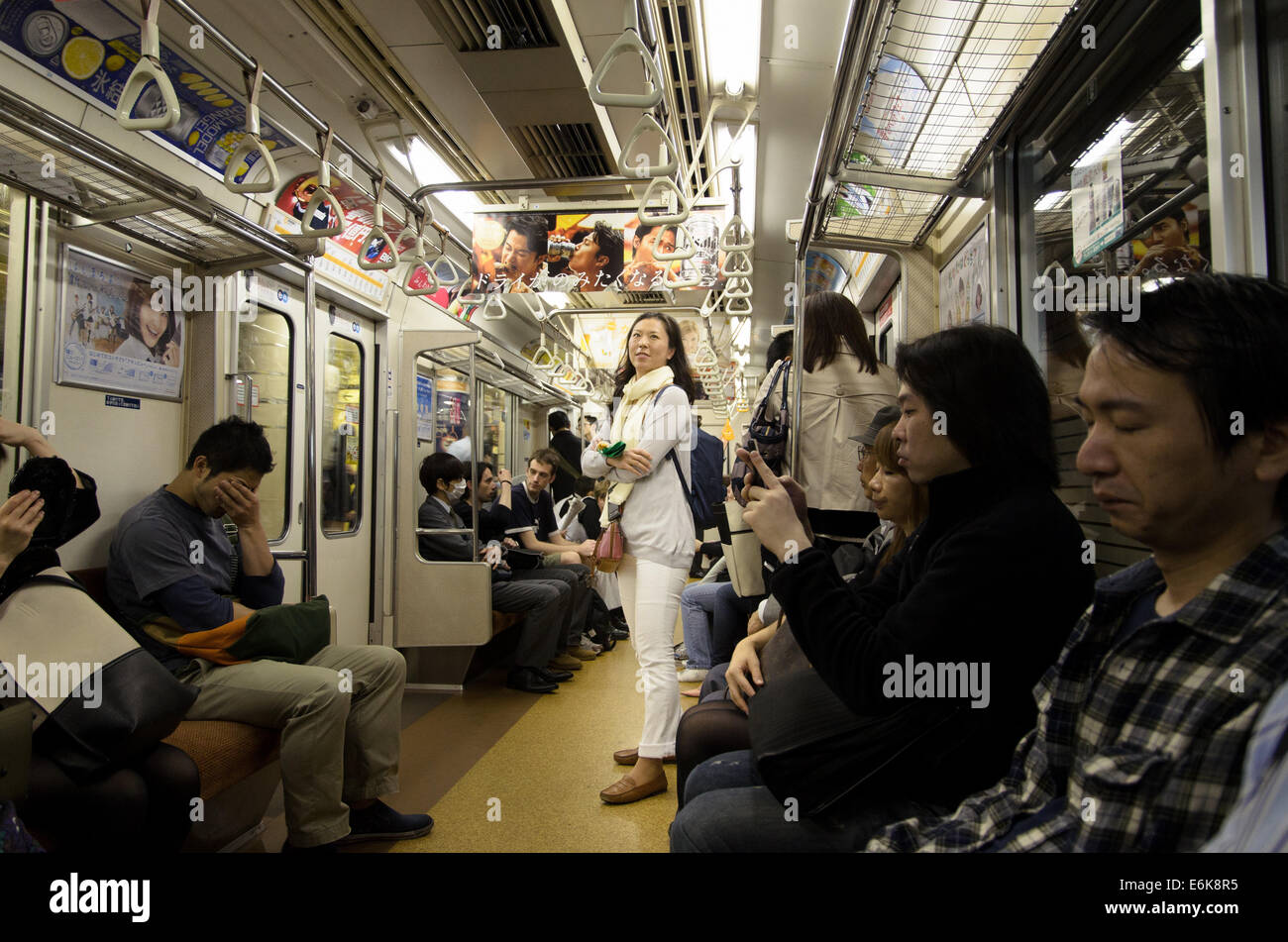 Tokyo metro, a young woman stand in the train wagon. Stock Photo