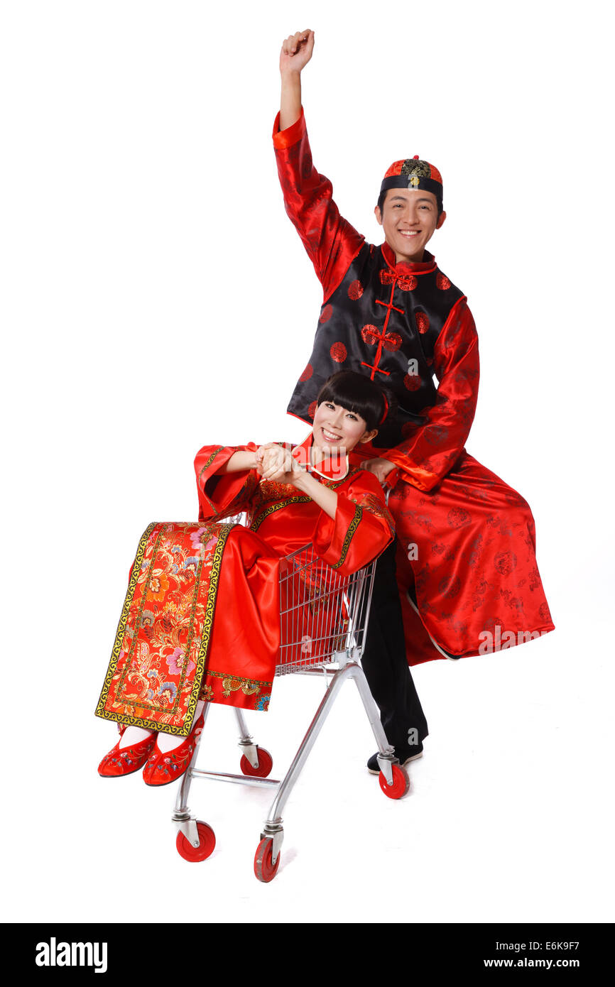 Young couple dressed in traditional clothes shopping with cart Stock Photo