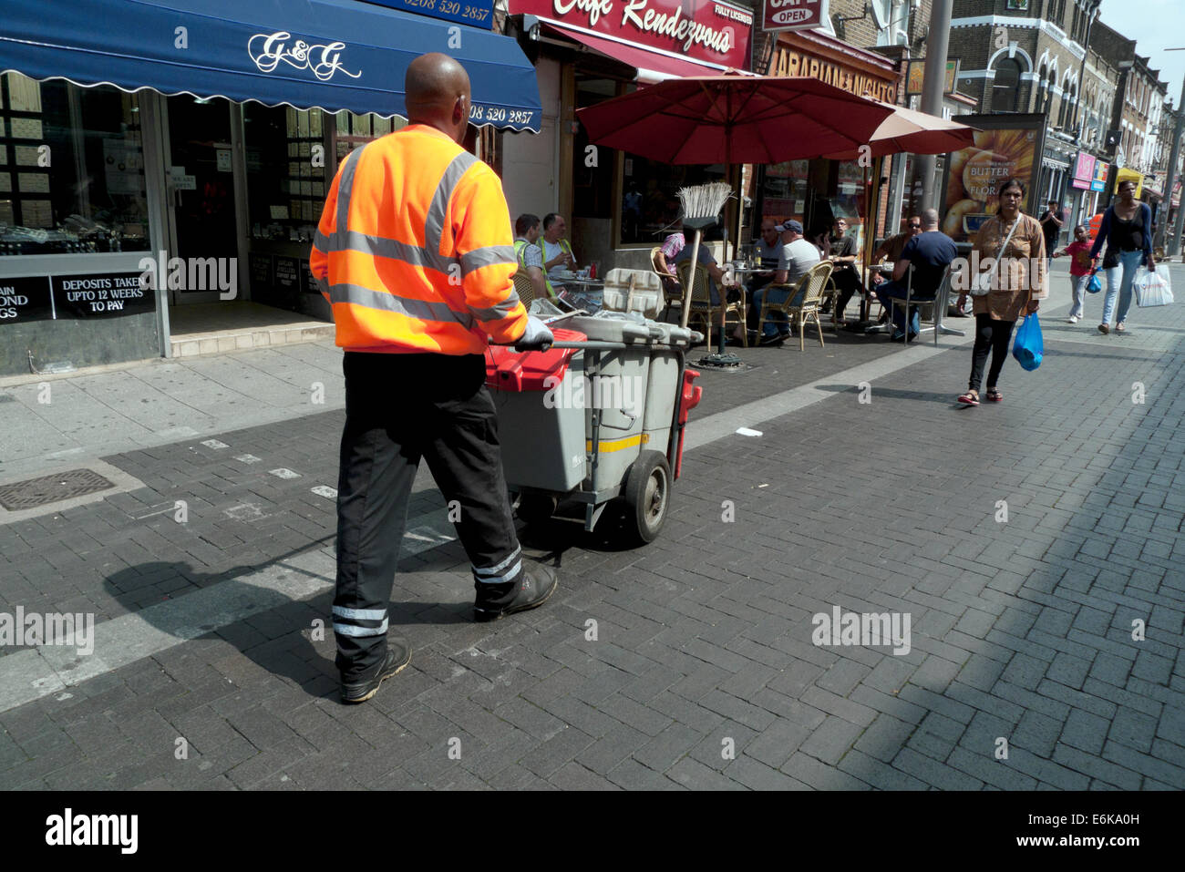 Street cleaner working in Walthamstow High Street on a sunny summer