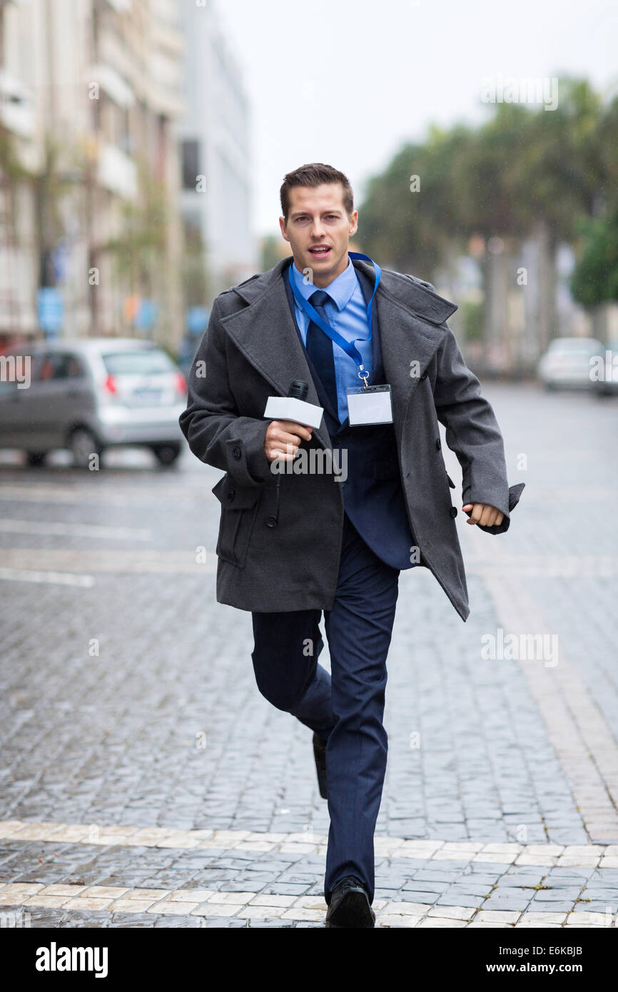 professional journalist running on urban street Stock Photo