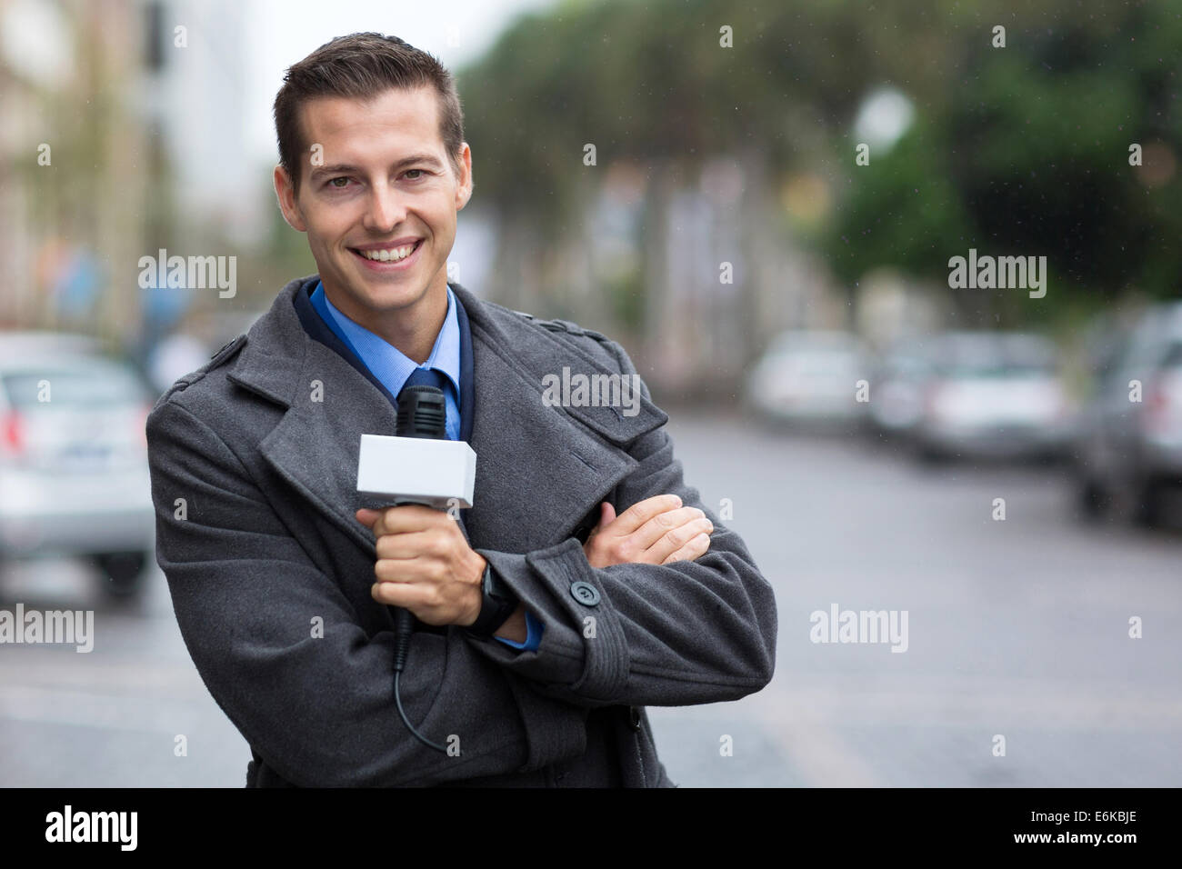 happy professional news reporter portrait in the city in the rain Stock Photo