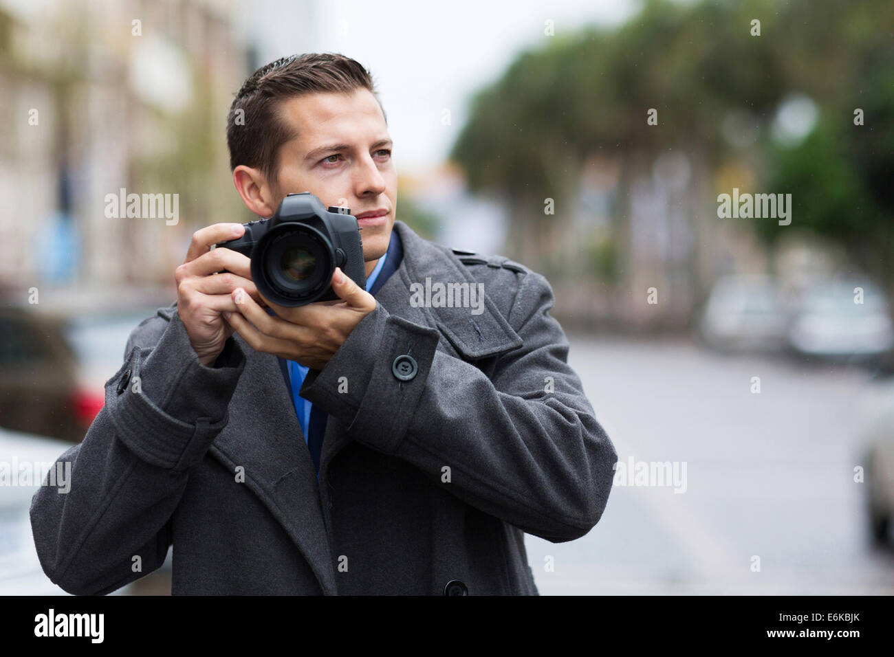 thoughtful male photographer with a camera on street Stock Photo