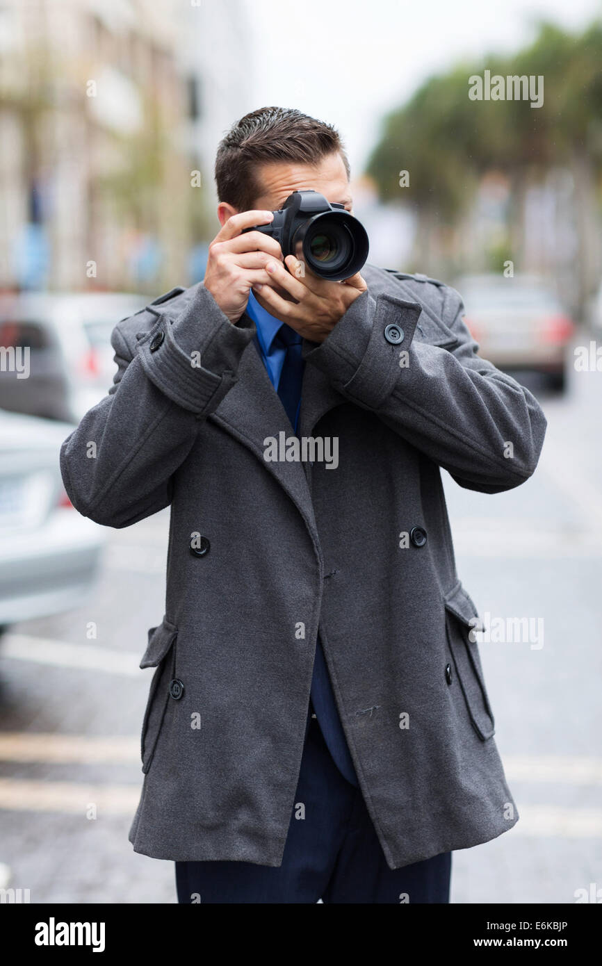 professional male photographer taking street photos in the city in a raining day Stock Photo