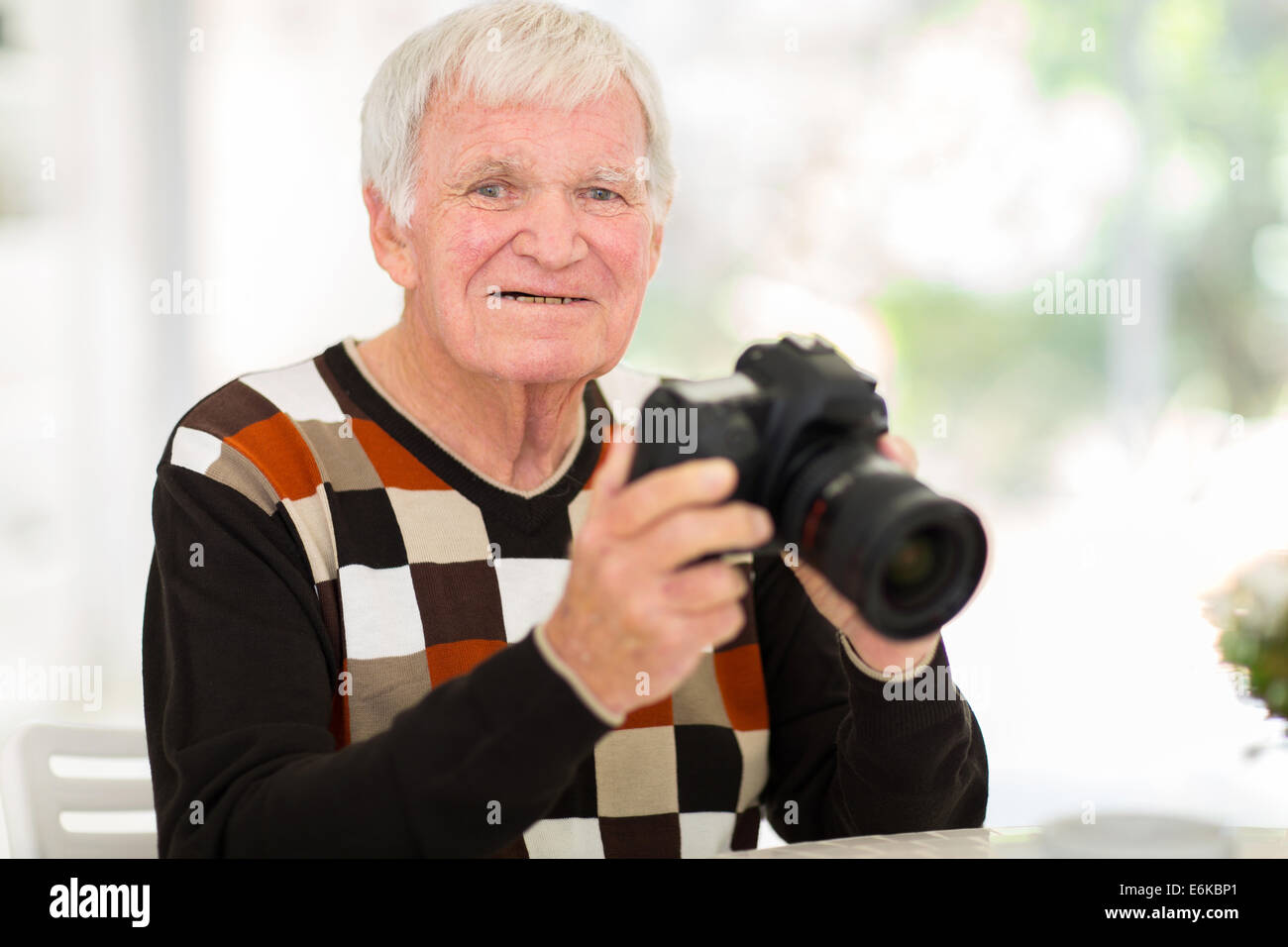 portrait of elderly man holding a digital SLR camera at home Stock ...