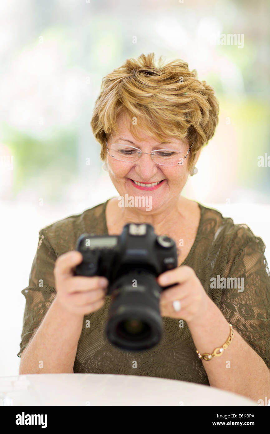 smiling retired woman viewing pictures on camera at home Stock Photo