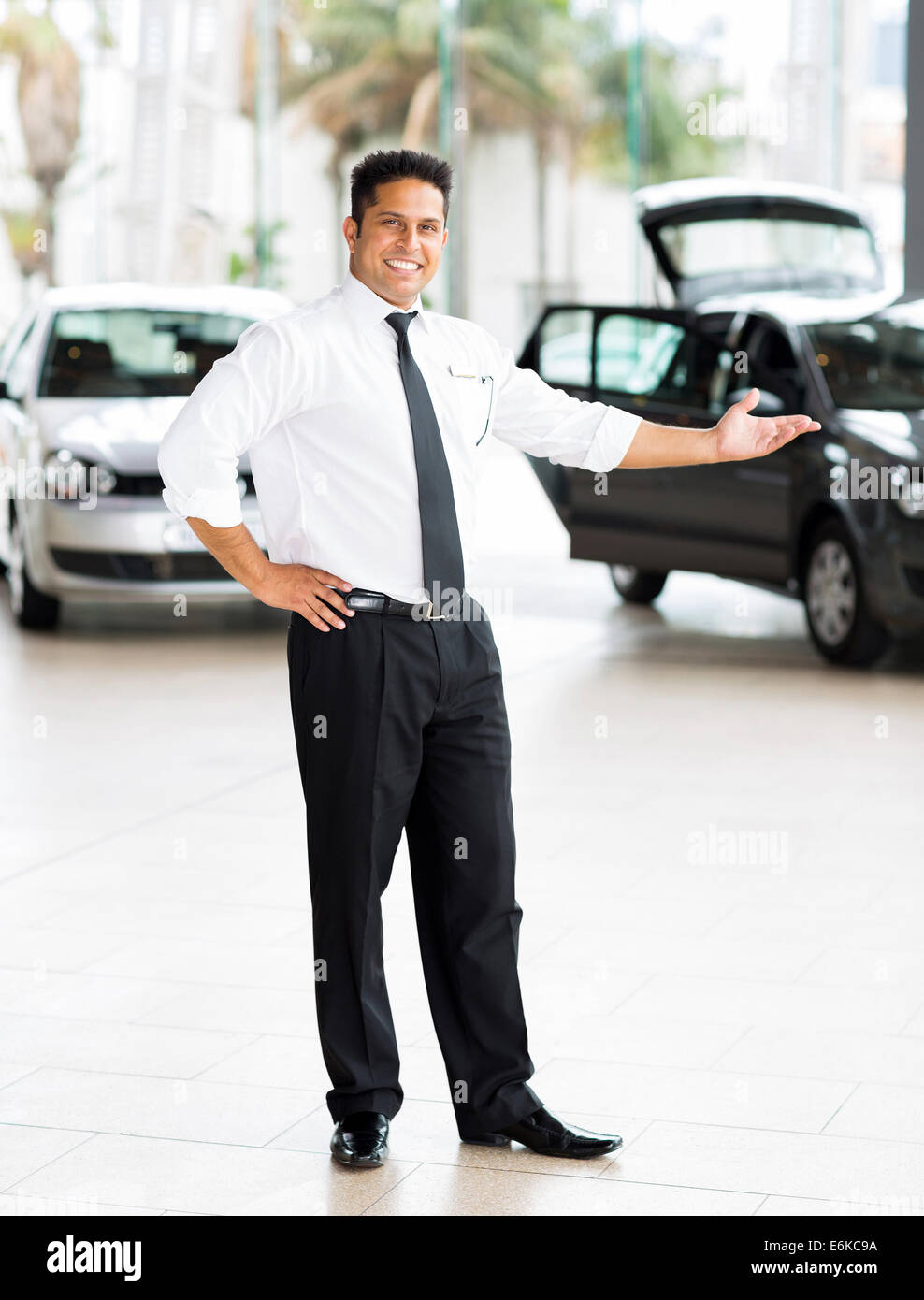Good Looking Indian Car Salesman Standing At Showroom Presenting New Cars Stock Photo Alamy