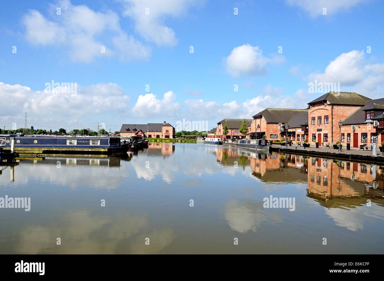 Narrowboats moored in front of bars, shops and restaurants in the canal