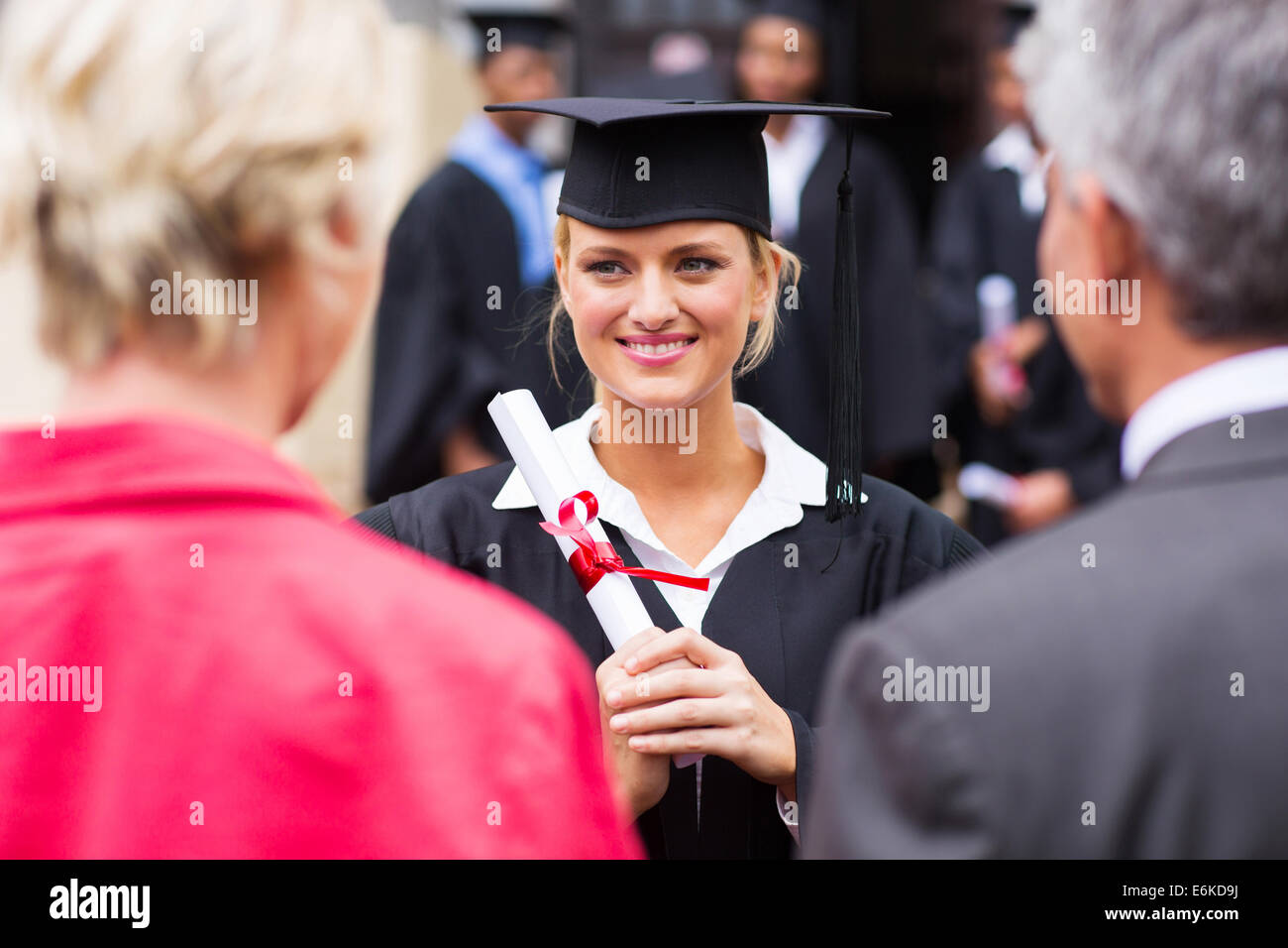 middle aged couple attending daughter's university graduation ceremony Stock Photo