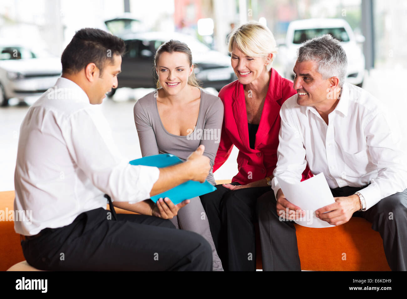 Indian car dealer explaining sales contract to the family buying a car Stock Photo