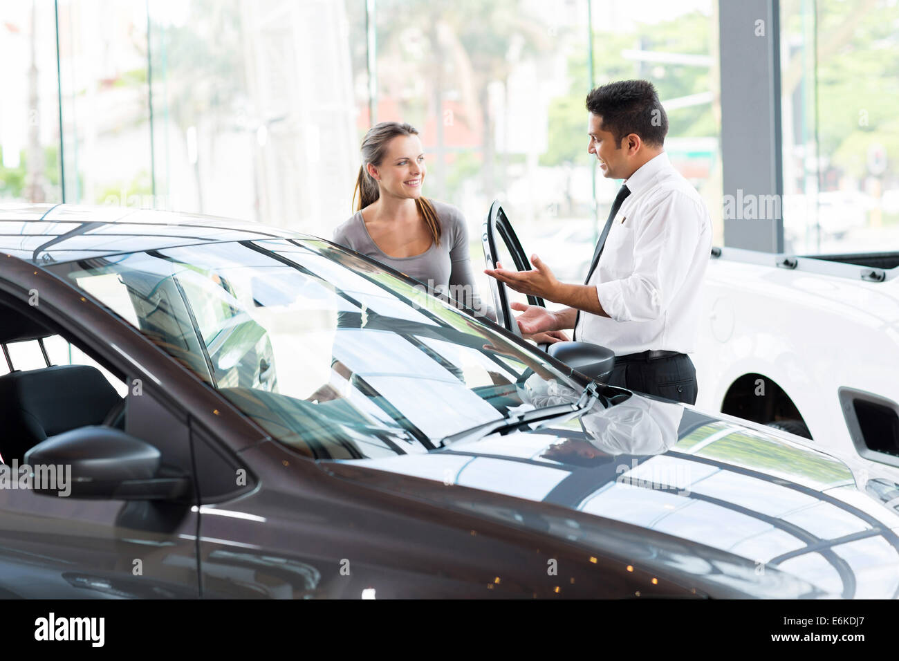 friendly vehicle dealer showing young woman new car Stock Photo Alamy