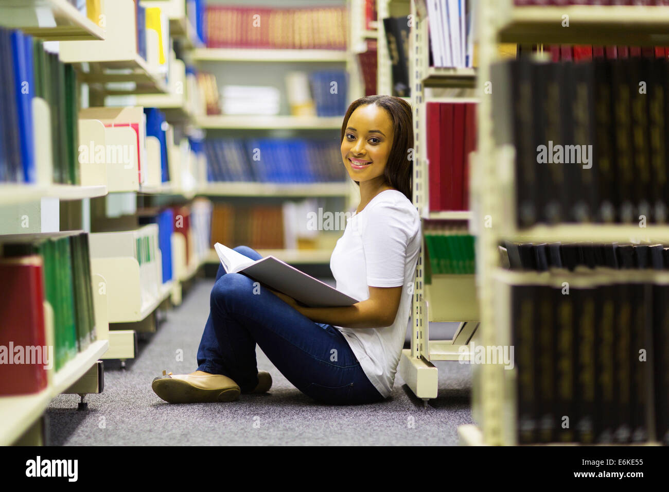 pretty African college girl sitting in library reading Stock Photo - Alamy