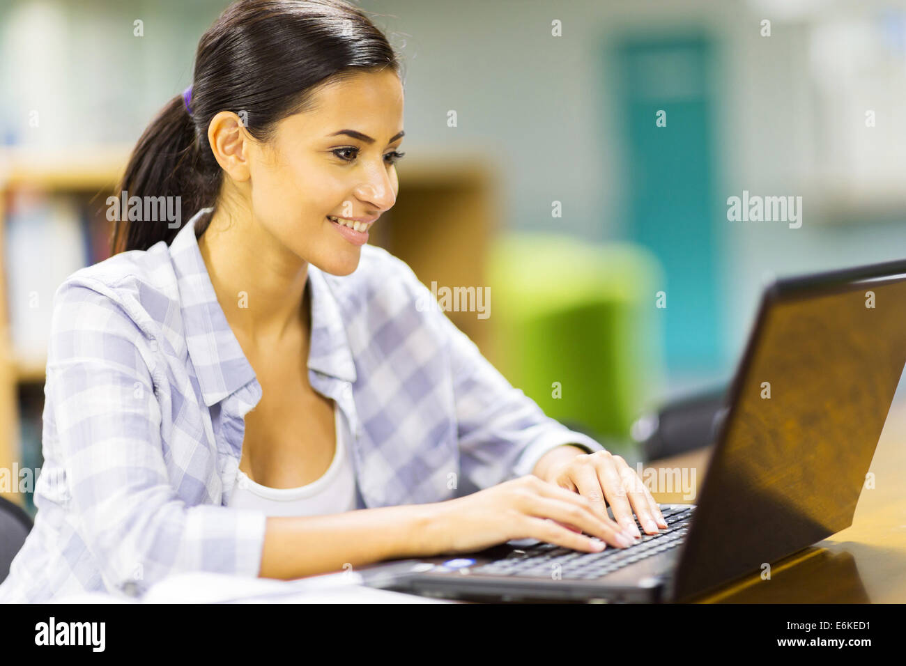 pretty female university student using laptop computer in library Stock ...