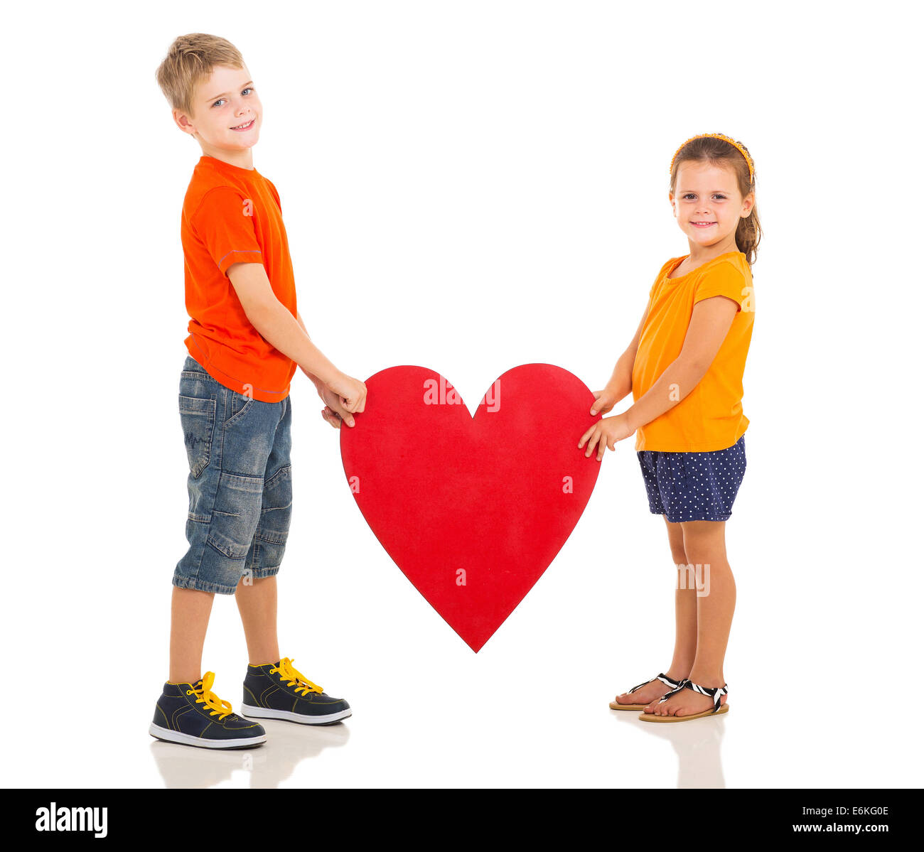 two happy kids holding heart shape isolated on white background Stock Photo