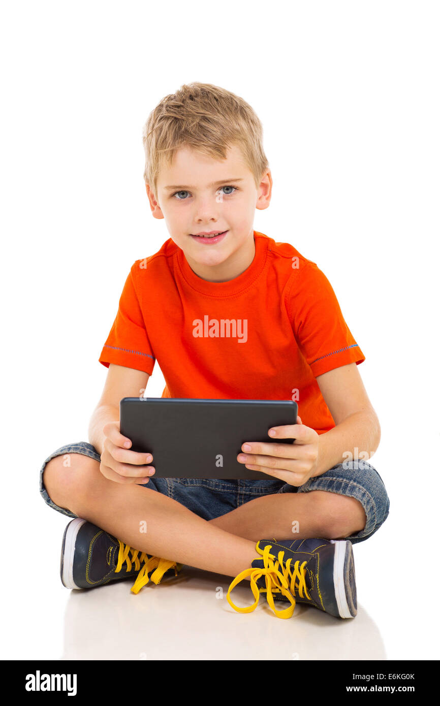 cute young boy with tablet computer sitting on the floor Stock Photo