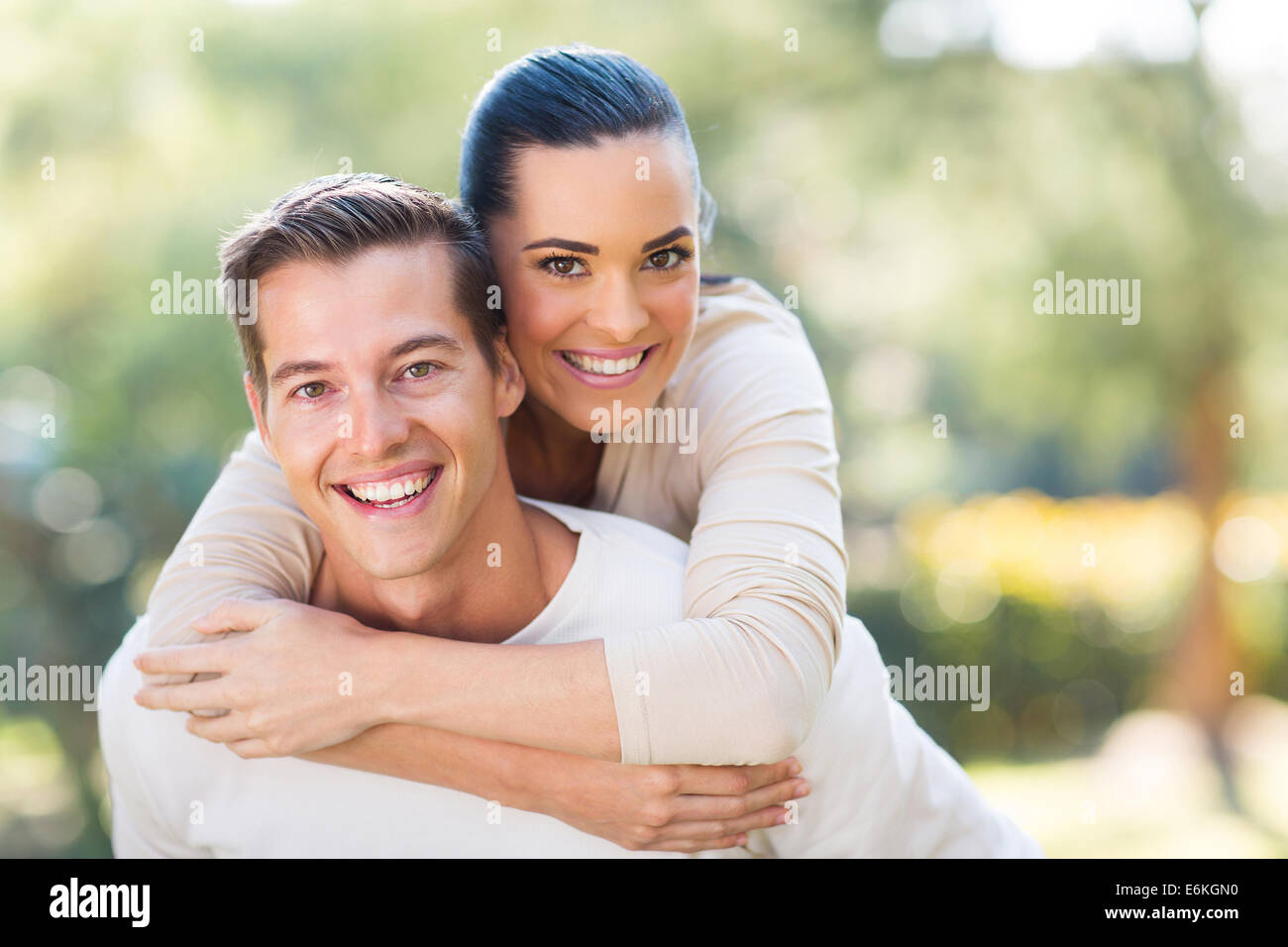 attractive young couple piggybacking outdoors Stock Photo