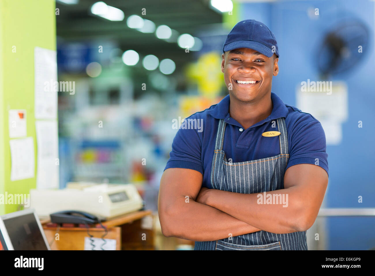 handsome African supermarket cashier standing at checkout Stock Photo