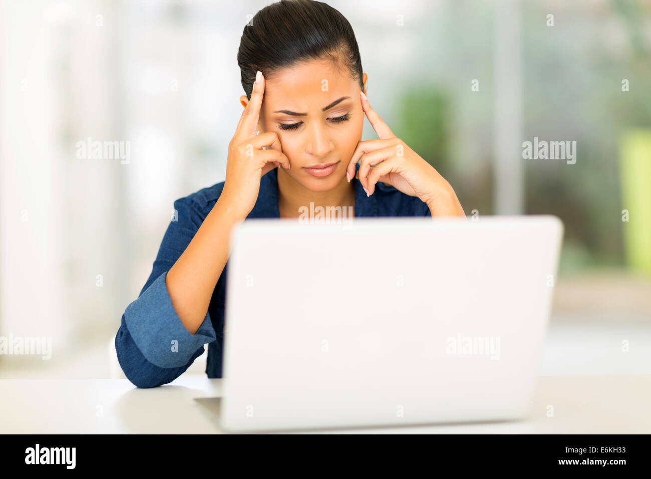 unhappy young woman looking at computer screen Stock Photo
