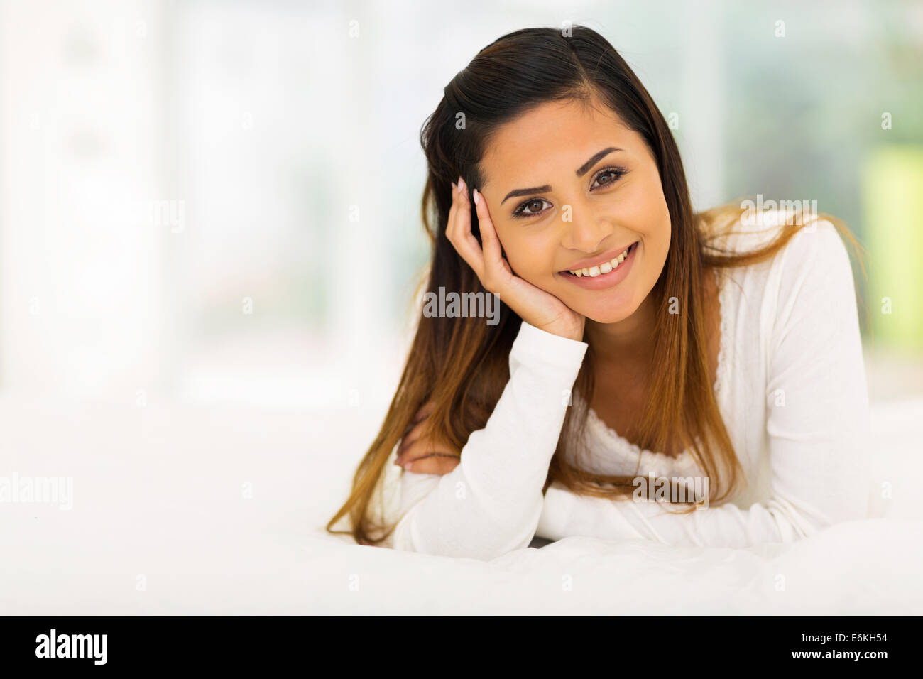 portrait of cute woman lying on bed Stock Photo