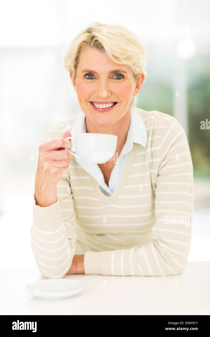 pretty middle aged woman drinking coffee at home Stock Photo