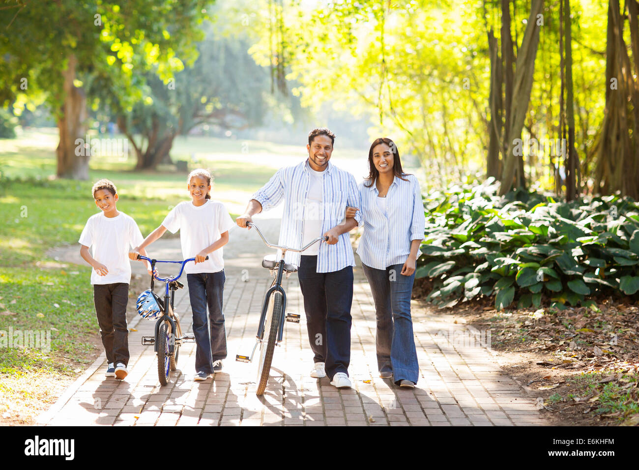 happy Indian family of four walking outdoors in the park Stock Photo