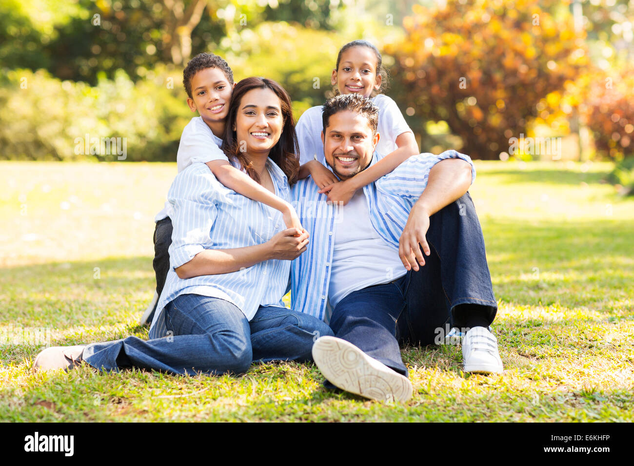 happy Indian family sitting on grass in the park Stock Photo - Alamy