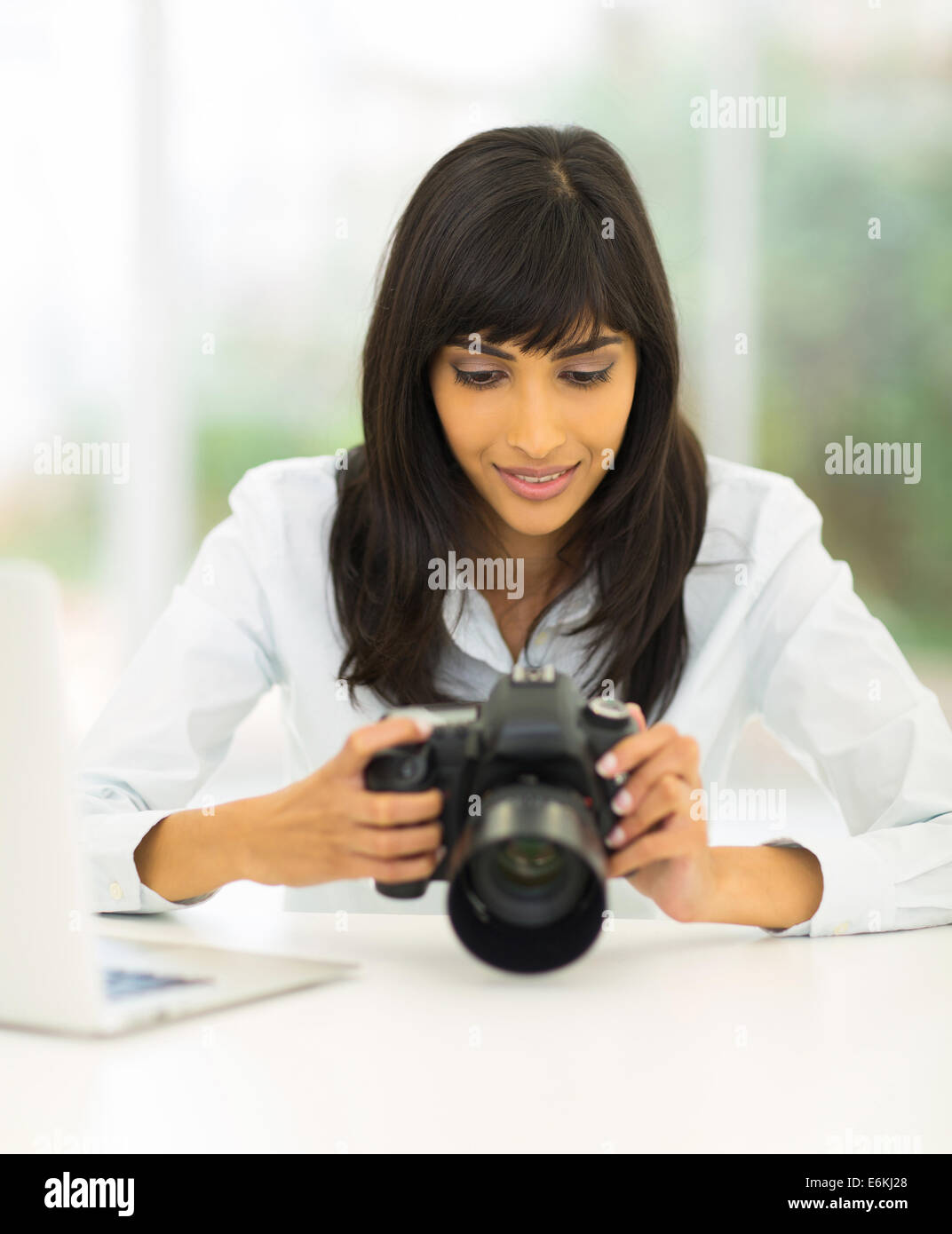 happy Indian photographer reviewing photos on dslr camera Stock Photo
