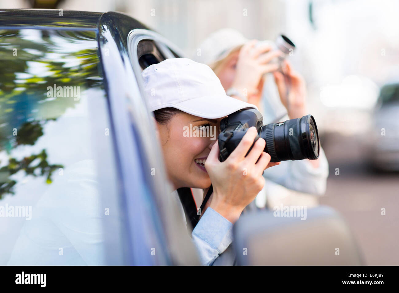 happy female tourist photographing the city from a car Stock Photo