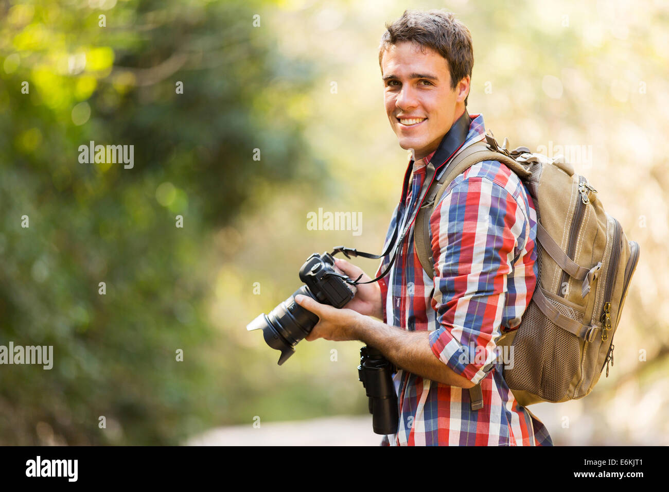 young man hiking in mountain with dslr camera Stock Photo