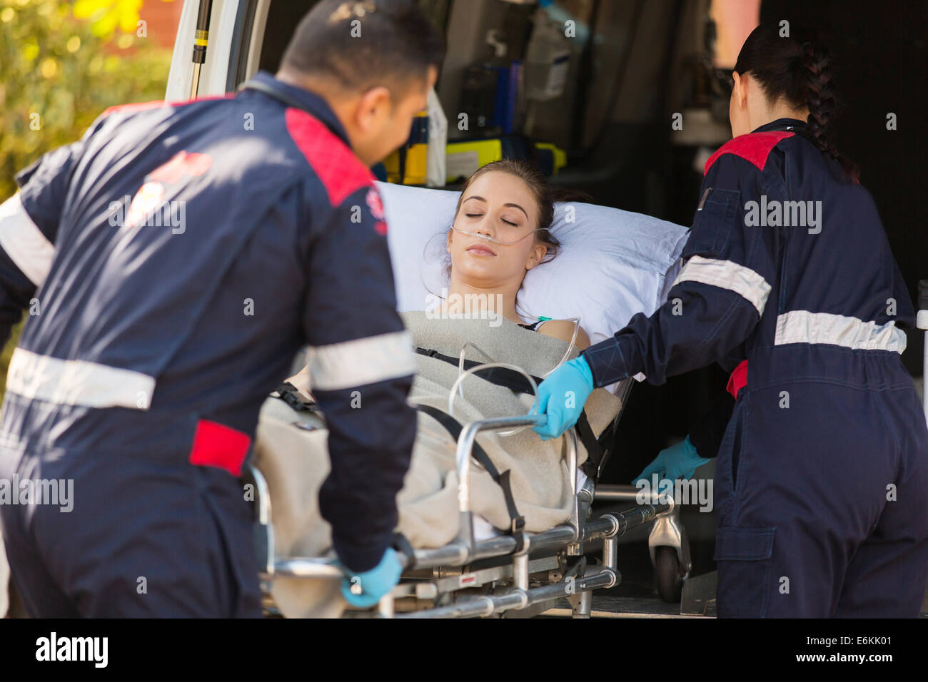 paramedics taking unconscious patient into an ambulance Stock Photo
