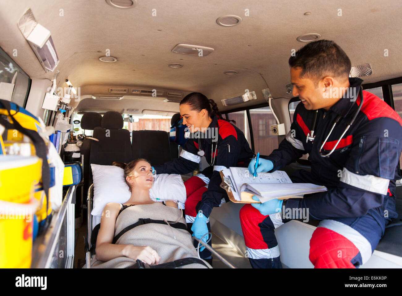 caring paramedics talking to patient on ambulance on the way to hospital Stock Photo