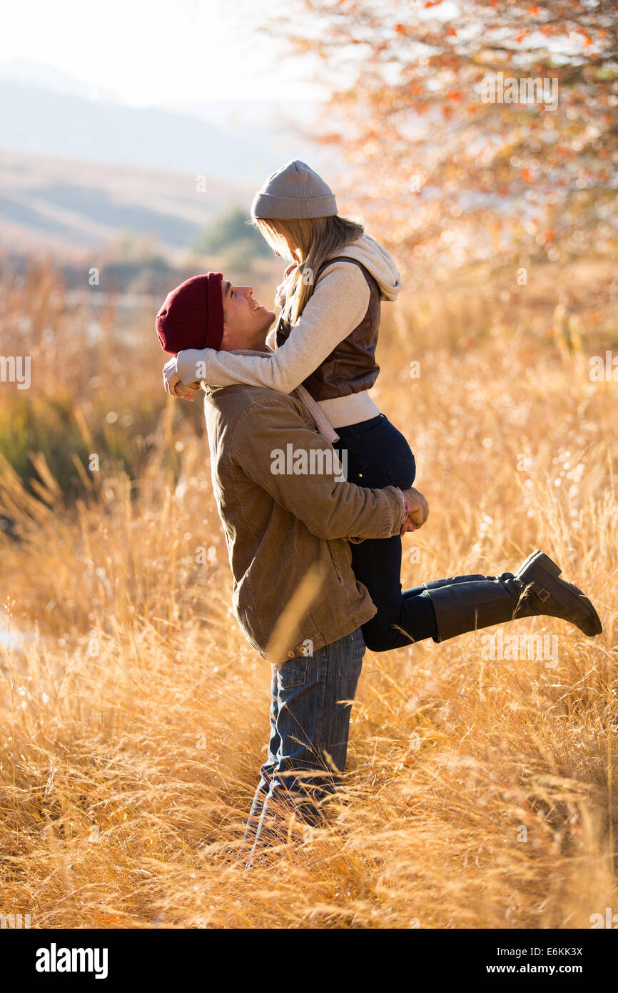 playful young man picking up his girlfriend by the lake in fall Stock Photo  - Alamy