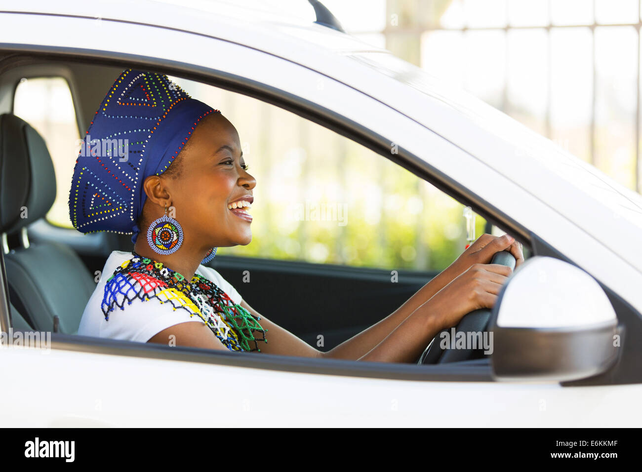 cheerful African female driver inside a car Stock Photo