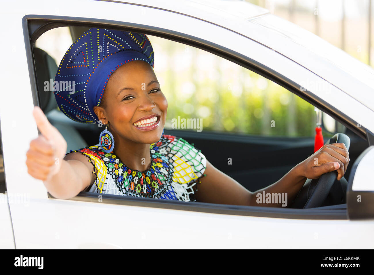 attractive south African woman giving thumb up inside her new car Stock Photo