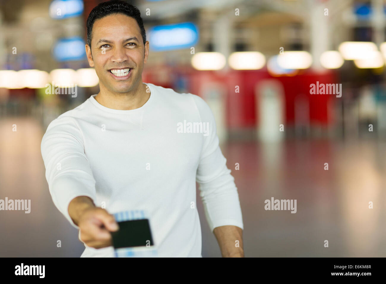 handsome mature man handing over air ticket at check in counter Stock Photo