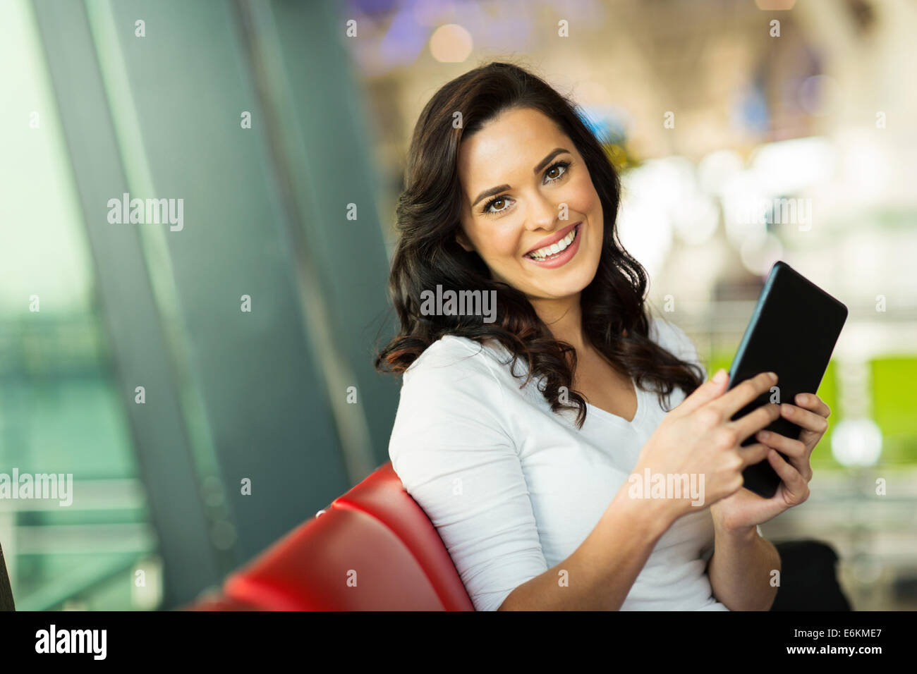 attractive woman holding tablet computer at airport Stock Photo