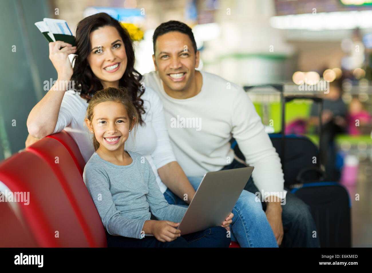 beautiful little girl sitting with her parents at airport Stock Photo