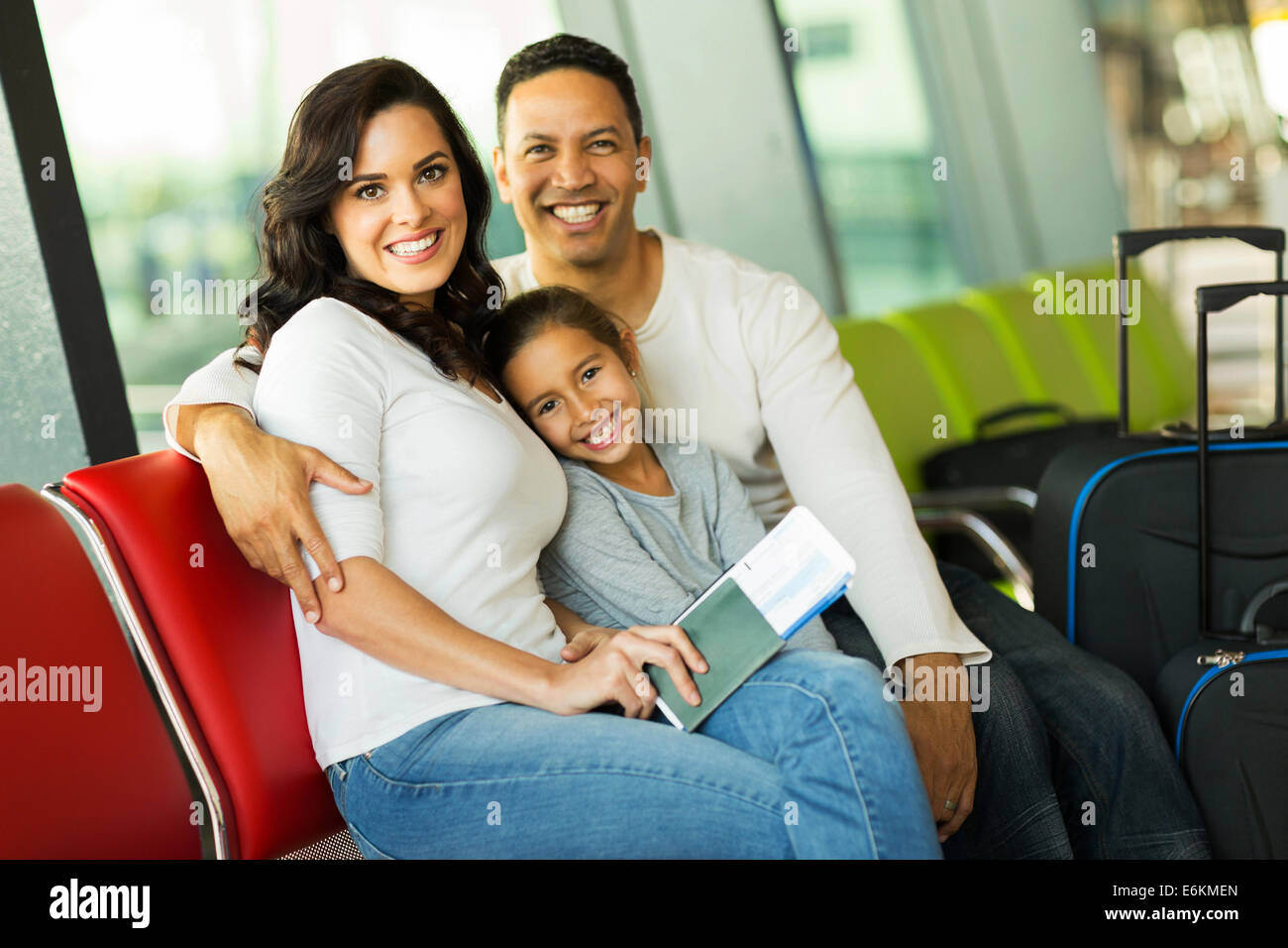 cheerful family of three at airport waiting for their flight Stock Photo