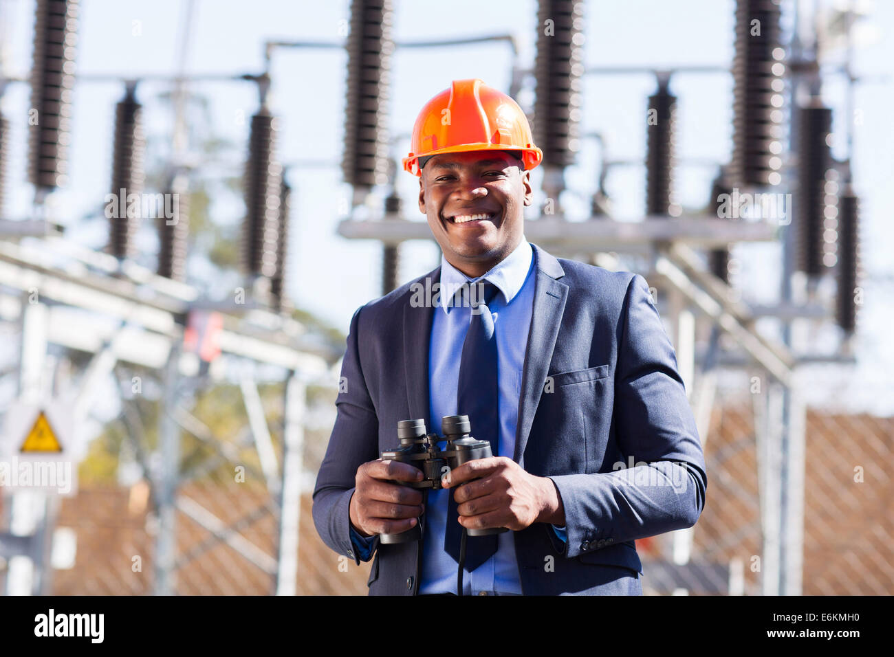 African industrial manager with binoculars in electricity power plant Stock Photo
