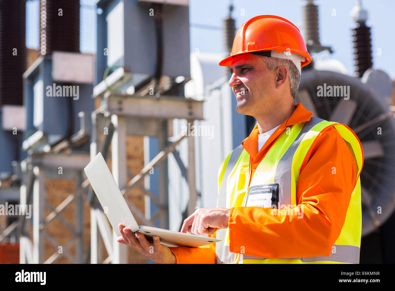 happy mature electrician using laptop Stock Photo