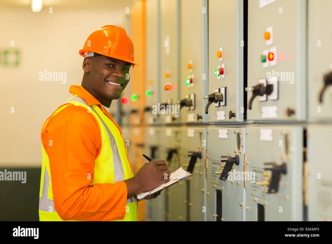 happy young African industrial technician taking machine readings Stock Photo