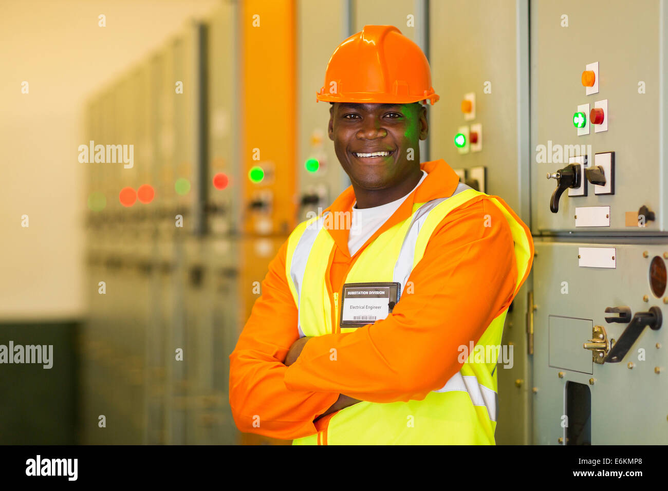 professional African industrial technician in front of control panel Stock Photo
