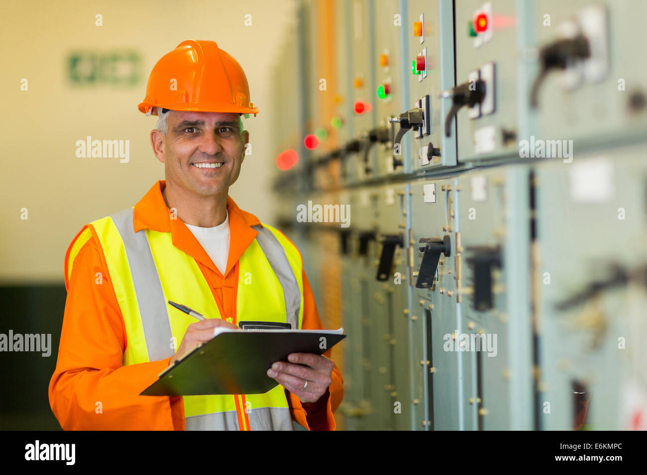 portrait of smiling mature electrician working in control room Stock Photo