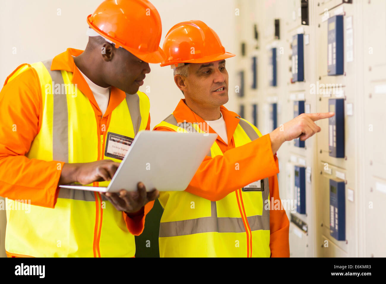 two professional electricians checking industrial control box Stock Photo