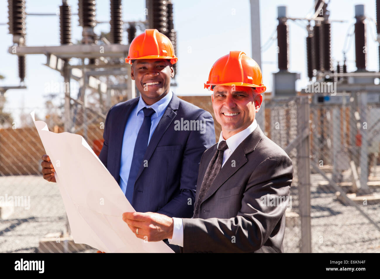 portrait of successful industrial managers holding blueprint at substation Stock Photo